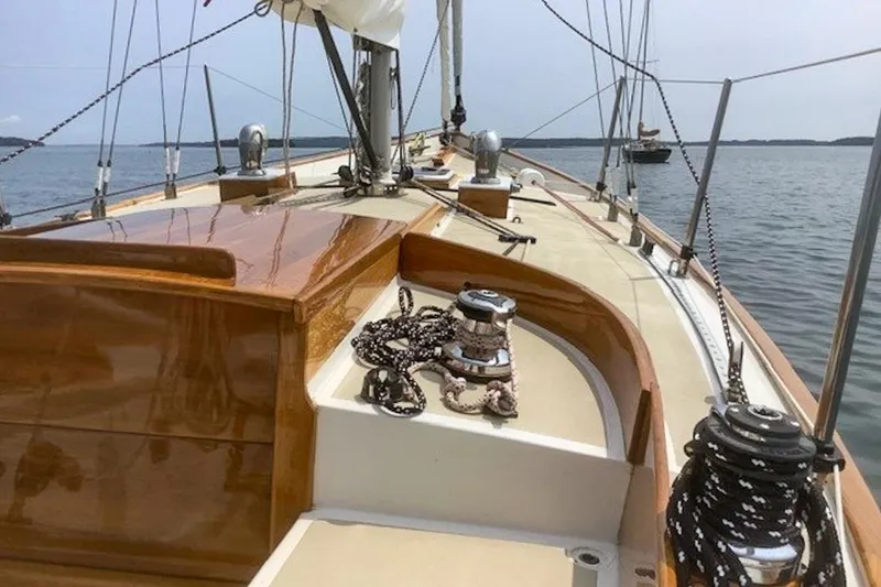 Slide: The Image of 1988 Morris Frances 26 sailboat deck with polished wood and rigging, sailing on calm waters. - 10