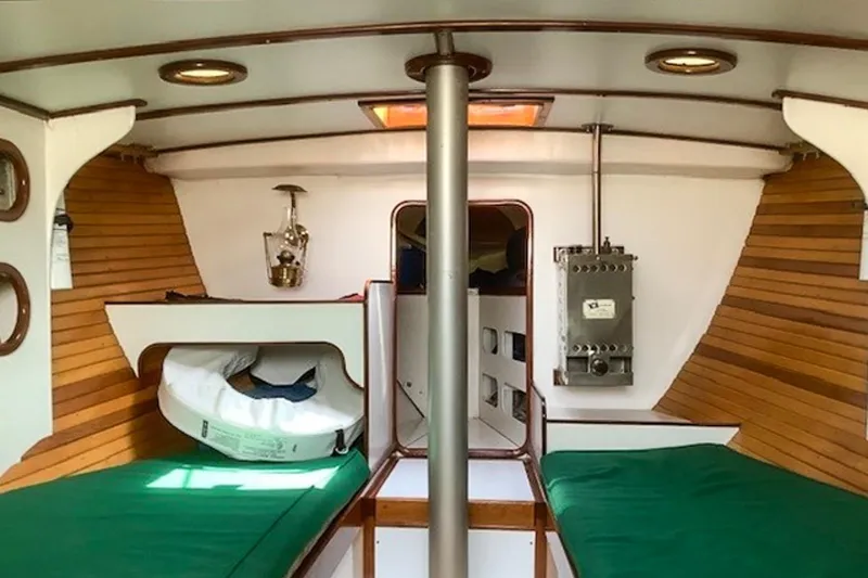 Slide: The Image of Interior of 1988 Morris Frances 26 sailboat with wooden paneling and green cushions. - 16