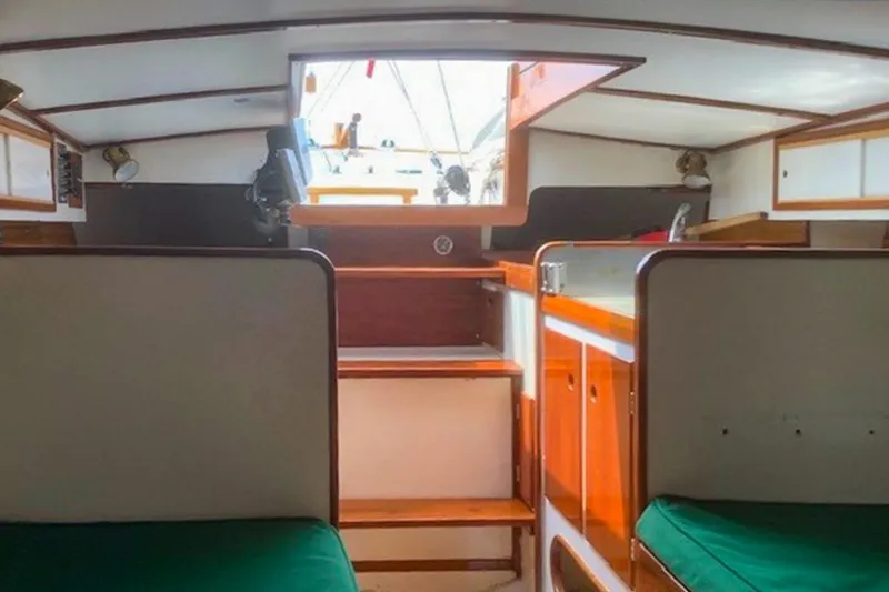 Slide: The Image of Interior of 1988 Morris Frances 26 sailboat with wooden cabinetry and green cushions. - 22