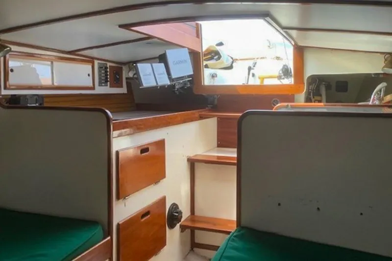 Slide: The Image of Interior of 1988 Morris Frances 26 sailboat with wooden cabinetry and green cushions. - 23