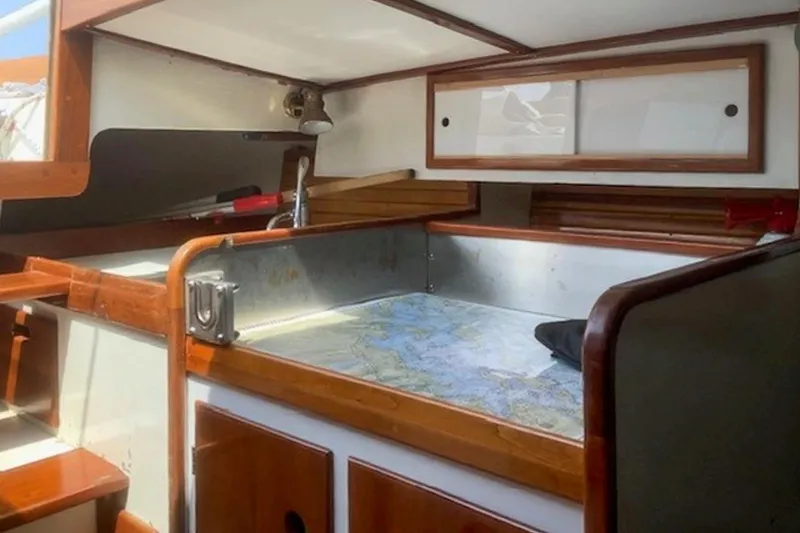 Slide: The Image of Interior of 1988 Morris Frances 26 sailboat with wooden cabinetry and nautical map. - 24