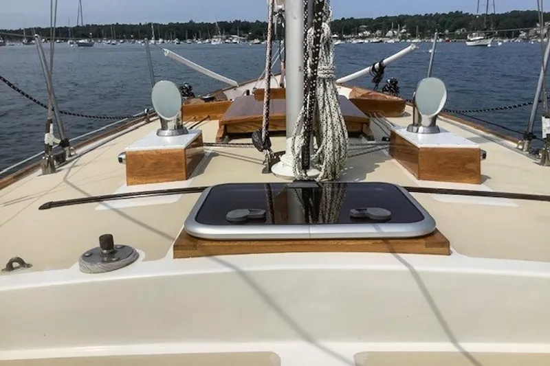 Slide: The Image of 1988 Morris Frances 26 sailboat deck with ropes and wooden accents, moored in a marina. - 5