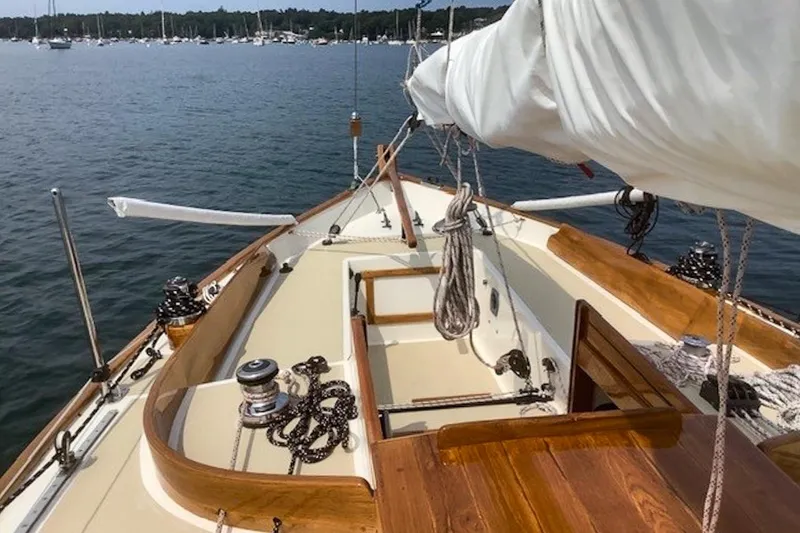 Slide: The Image of 1988 Morris Frances 26 sailboat deck with wooden accents, anchored in a serene harbor. - 7