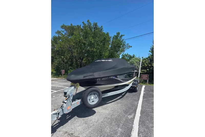 Slide: The Image of 2009 Sea Ray 175 Sport boat on trailer, covered, parked in a lot. - 2