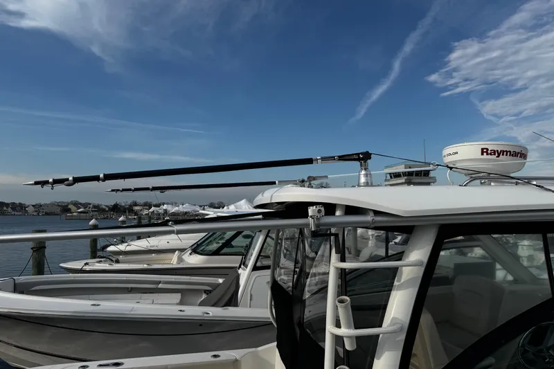 Slide: The Image of 2016 Boston Whaler 315 Conquest docked, featuring Raymarine radar and clear blue sky. - 11