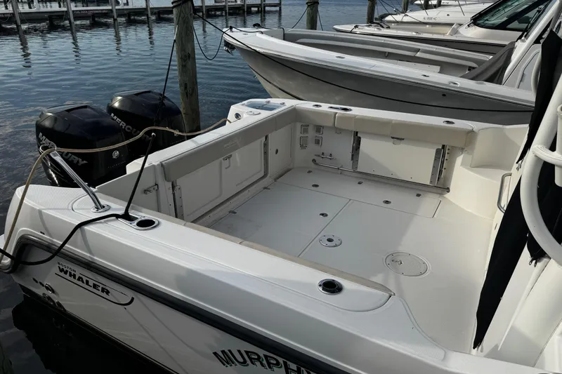 Slide: The Image of 2016 Boston Whaler 315 Conquest boat docked, featuring spacious deck and twin Mercury engines. - 12