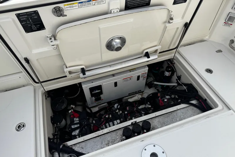 Slide: The Image of Engine compartment of a 2016 Boston Whaler 315 Conquest, featuring Kohler generator and wiring. - 16