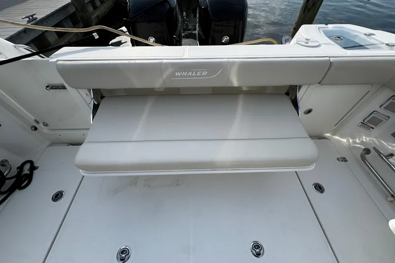 Slide: The Image of 2016 Boston Whaler 315 Conquest boat with foldable seating and dual outboard motors. - 17