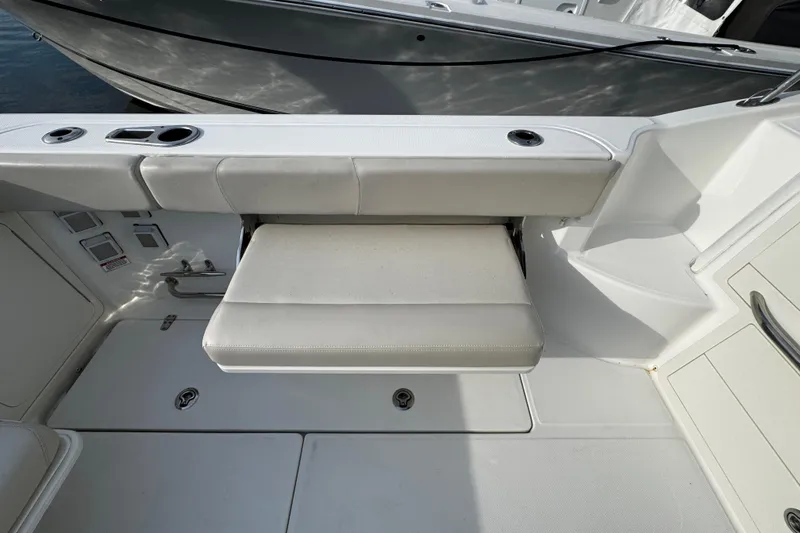 Slide: The Image of 2016 Boston Whaler 315 Conquest boat interior with foldable seat and storage compartments. - 18