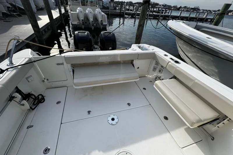 Slide: The Image of 2016 Boston Whaler 315 Conquest boat interior with seating and docked engines. - 19