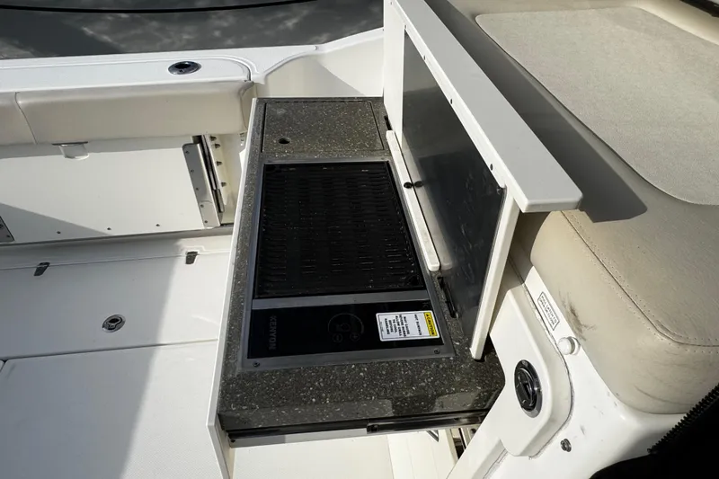 Slide: The Image of 2016 Boston Whaler 315 Conquest boat interior with built-in grill and seating area. - 21