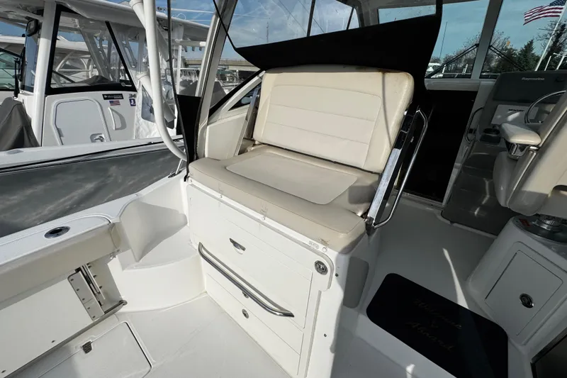Slide: The Image of 2016 Boston Whaler 315 Conquest interior seating area with white cushioned seats. - 23