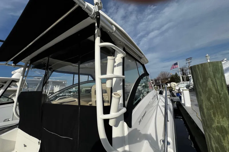 Slide: The Image of 2016 Boston Whaler 315 Conquest docked, showcasing sleek design and fishing rod holders. - 25