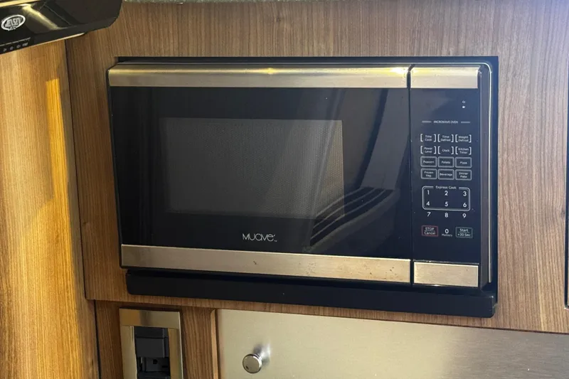 Slide: The Image of Microwave oven inside a 2016 Boston Whaler 315 Conquest boat's wooden interior. - 41