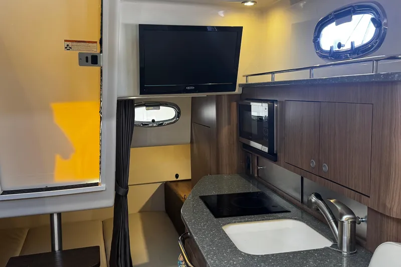 Slide: The Image of Interior of a 2016 Boston Whaler 315 Conquest boat with kitchenette and TV. - 43