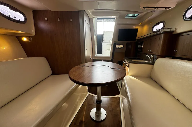 Slide: The Image of Interior of 2016 Boston Whaler 315 Conquest, featuring seating, table, and kitchenette. - 53