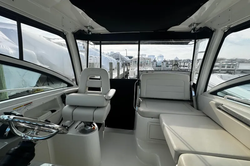 Slide: The Image of Interior view of 2016 Boston Whaler 315 Conquest boat, featuring helm and seating area. - 59