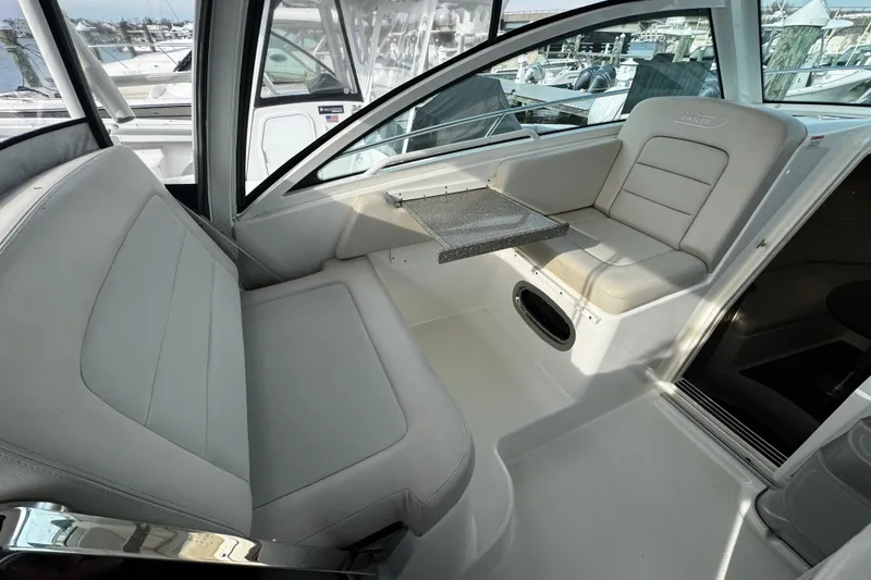 Slide: The Image of 2016 Boston Whaler 315 Conquest interior seating area with table, showcasing luxury and comfort. - 62