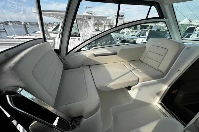 Slide: The Image of Interior of 2016 Boston Whaler 315 Conquest boat with comfortable seating and window view. - 63