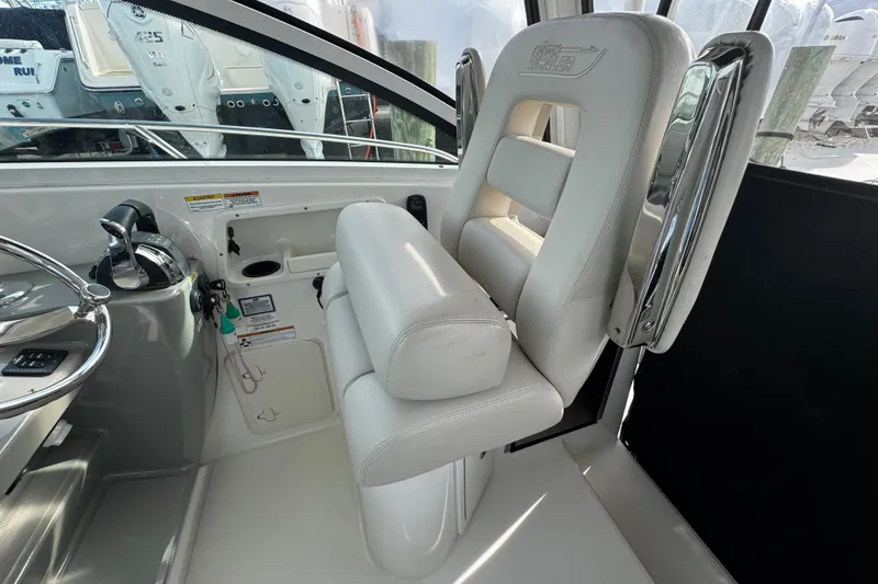 Slide: The Image of 2016 Boston Whaler 315 Conquest helm with white seating and control panel. - 73