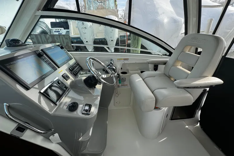 Slide: The Image of 2016 Boston Whaler 315 Conquest helm with dual displays and comfortable captain's chair. - 74