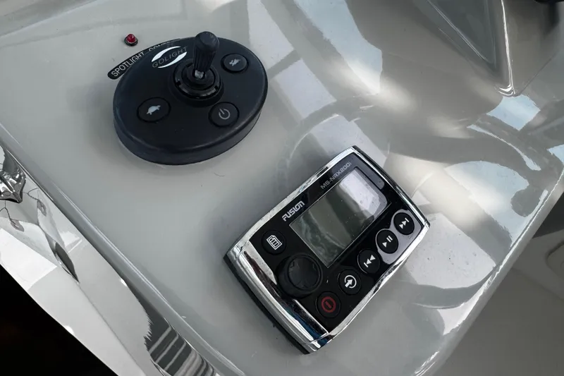 Slide: The Image of Control panel of a 2016 Boston Whaler 315 Conquest boat with spotlight and audio controls. - 76