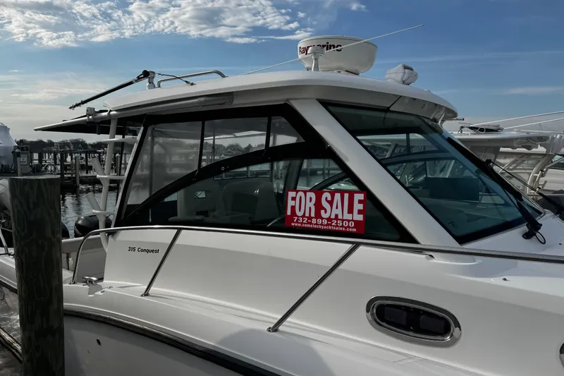 Slide: The Image of 2016 Boston Whaler 315 Conquest boat for sale at marina, clear sky background. - 8