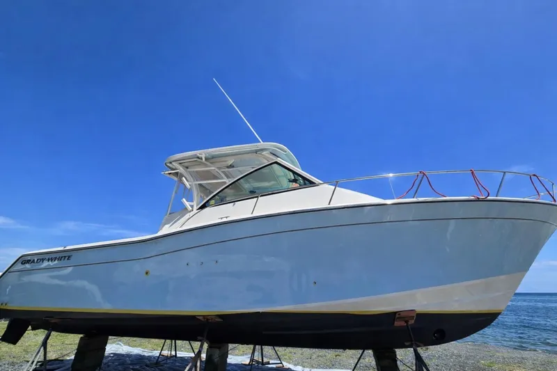 Slide: The Image of 2021 Grady-White Express 330 boat on stands under clear blue sky. - 2