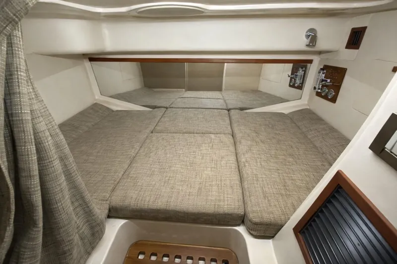 Slide: The Image of 2021 Grady-White Express 330 cabin interior with cushioned sleeping area and wooden accents. - 22
