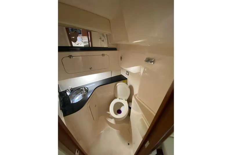 Slide: The Image of 2021 Grady-White Express 330 boat bathroom with sink, toilet, and storage cabinet. - 24