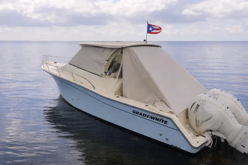 Slide: The Image of 2021 Grady-White Express 330 boat with canopy on calm water, Puerto Rican flag flying. - 26
