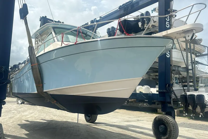 Slide: The Image of 2021 Grady-White Express 330 boat lifted by crane at marina. - 28