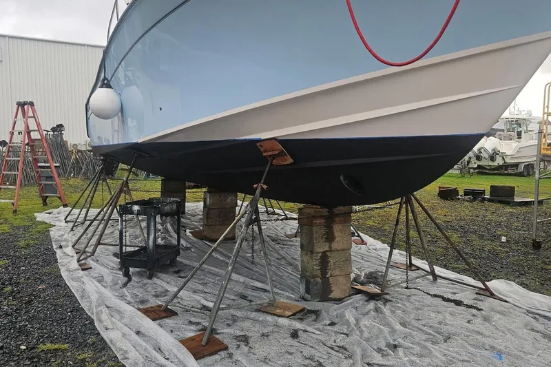 Slide: The Image of 2021 Grady-White Express 330 boat on stands for maintenance in a yard. - 29