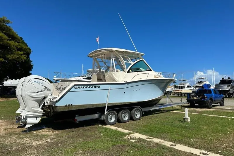 Slide: The Image of 2021 Grady-White Express 330 boat on trailer with Yamaha engines, parked outdoors. - 30
