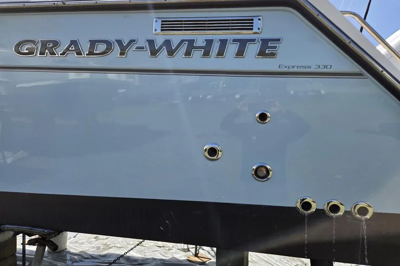 Slide: The Image of 2021 Grady-White Express 330 boat hull with chrome fittings and brand logo. - 4