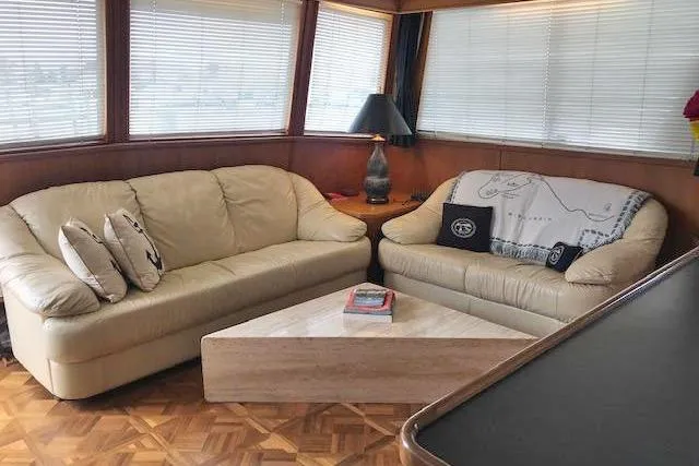 Slide: The Image of Luxurious 1985 Chris Craft 500 yacht interior with beige sofas and a marble coffee table. - 11
