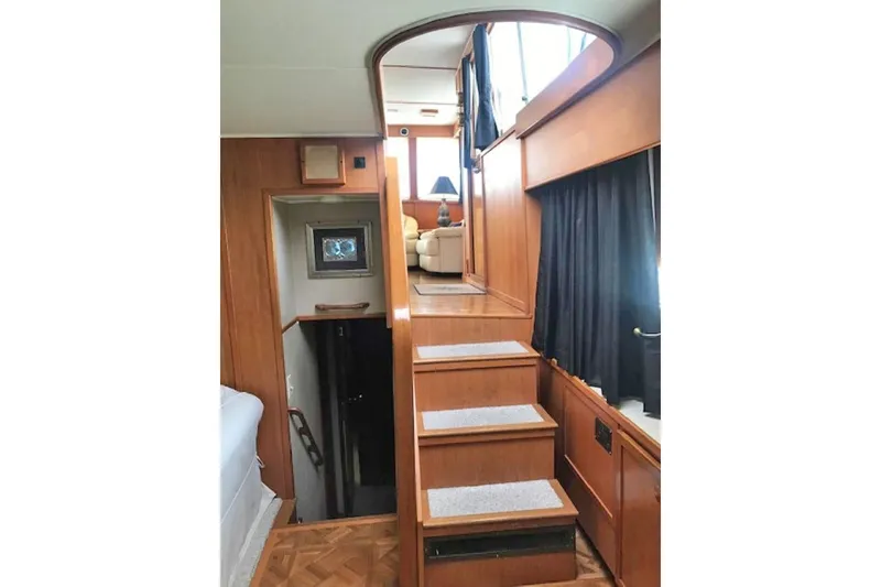 Slide: The Image of Interior of 1985 Chris Craft 500 yacht with wooden stairs and cozy seating area. - 12