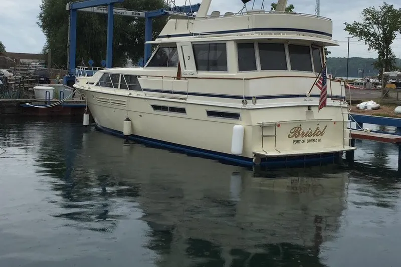 Slide: The Image of 1985 Chris Craft 500 yacht docked at marina, displaying American flag. - 2