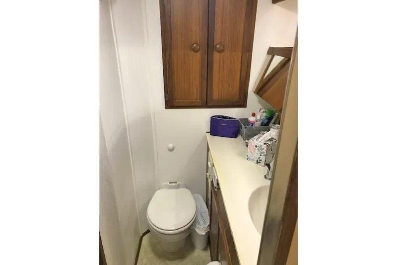 Slide: The Image of 1985 Chris Craft 500 yacht bathroom with wooden cabinets and compact sink area. - 30