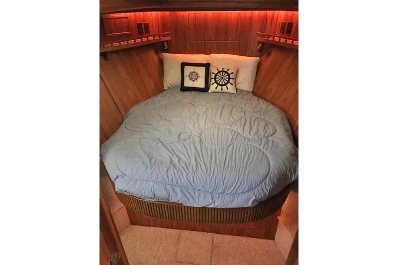 Slide: The Image of Cozy cabin bedroom in 1985 Chris Craft 500 yacht with nautical-themed pillows. - 31