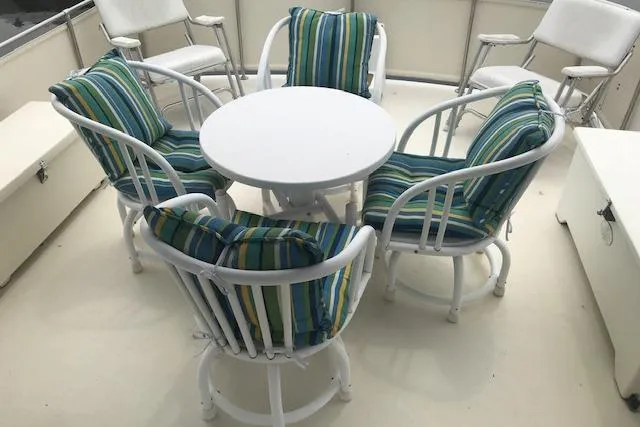 Slide: The Image of 1985 Chris Craft 500 yacht deck with striped cushioned chairs and round table. - 43