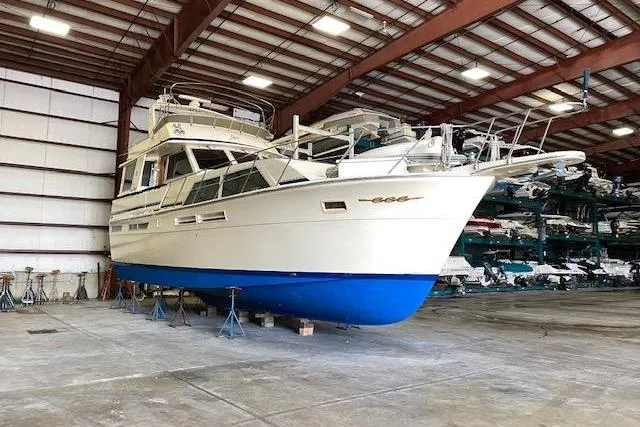 Slide: The Image of 1985 Chris-Craft 500 Constellation yacht in indoor storage, showcasing classic design and blue hull. - 48