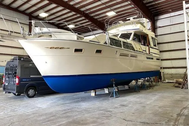 Slide: The Image of 1985 Chris-Craft 500 Constellation yacht in indoor storage, showcasing sleek design and blue hull. - 49