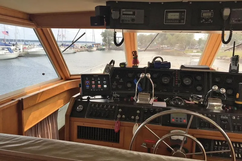 Slide: The Image of Interior view of 1985 Chris Craft 500 yacht cockpit with navigation controls and marina view. - 5