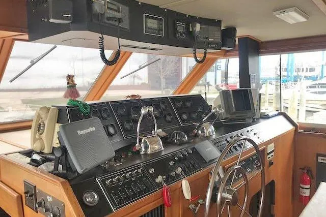 Slide: The Image of 1985 Chris Craft 500 yacht helm with navigation equipment and wooden dashboard. - 6