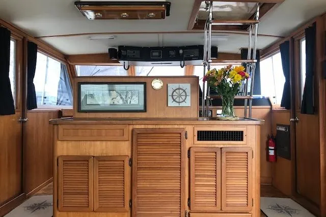 Slide: The Image of Interior of 1985 Chris-Craft 500 Constellation yacht with wood paneling and floral arrangement. - 8