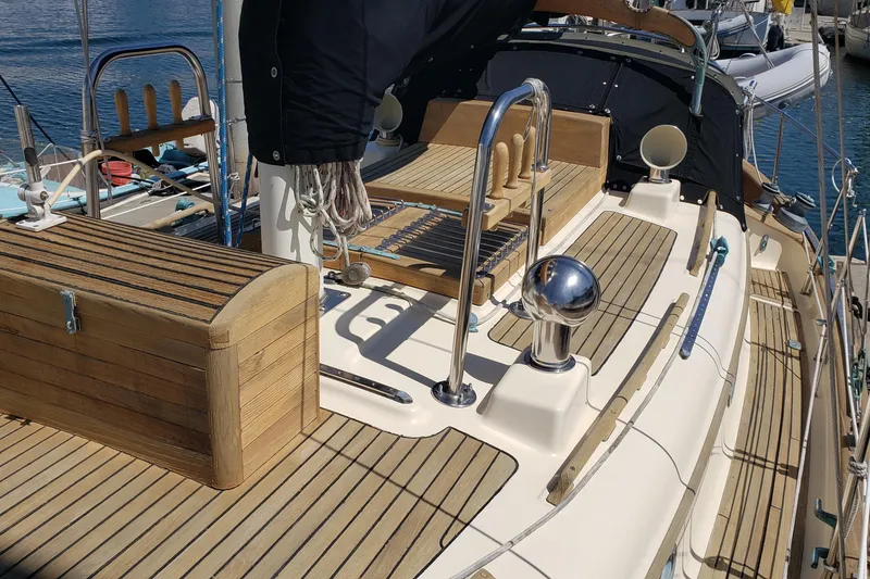 Slide: The Image of 1987 Hans Christian 33 sailboat deck with wooden accents and nautical equipment. - 12