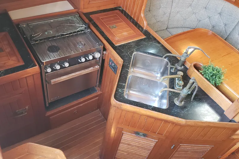Slide: The Image of 1987 Hans Christian 33 yacht kitchen with stove, double sink, and wooden cabinetry. - 28