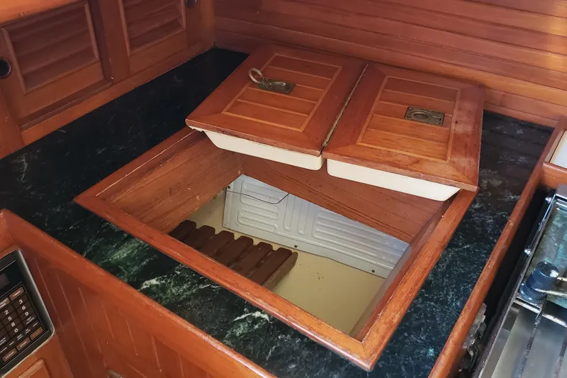 Slide: The Image of Wooden galley storage on 1987 Hans Christian 33 sailboat, featuring a built-in cooler. - 30