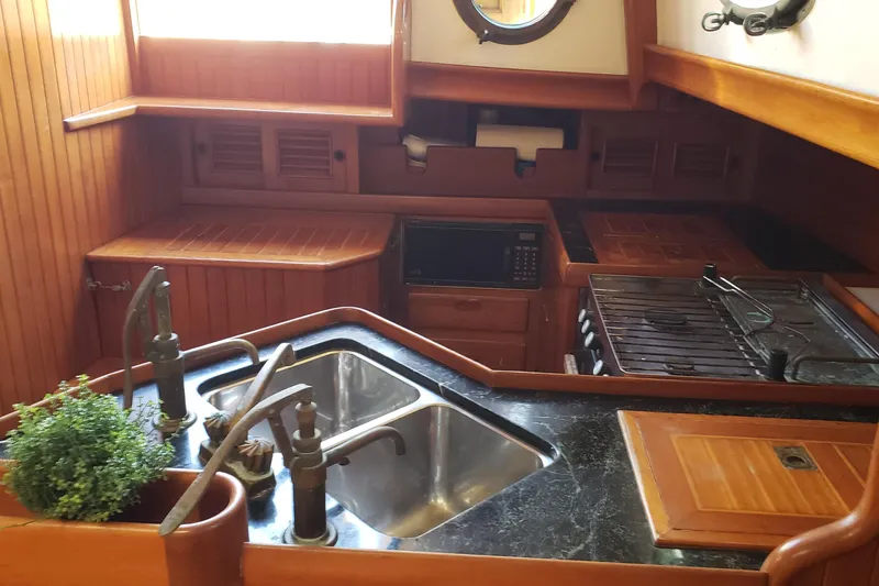Slide: The Image of Galley kitchen in 1987 Hans Christian 33 sailboat with wooden cabinetry and dual sink. - 32